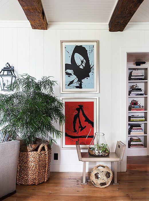 Several pieces of art—including these two contrasting contemporary paintings—are hung at lower-than-traditional heights to suit their particular space. “It brings in a little bit more personality,” says Thom.
