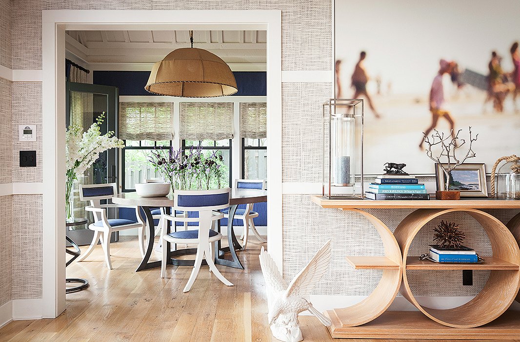 Repeating circular shapes—including the console, the dining table, the chandelier, and the metal end table—add a sense of dynamism and connect the living and dining rooms.
