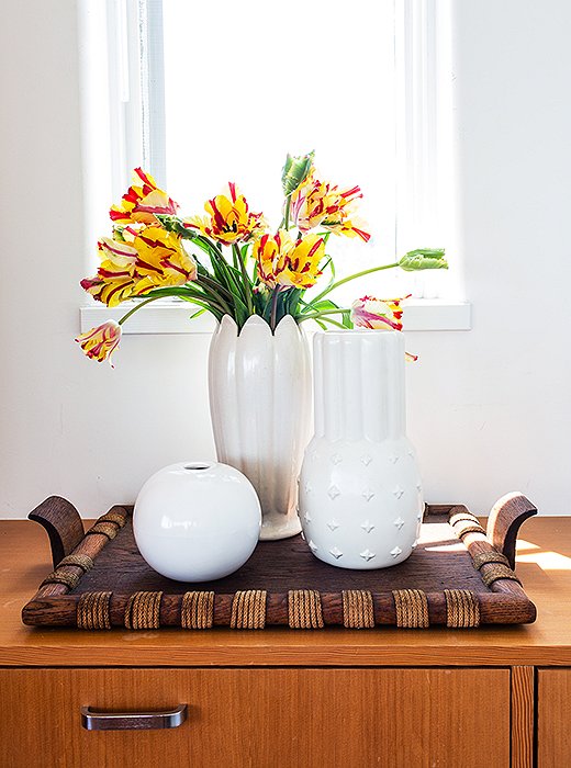 A trio of vintage ceramic vases sits atop one of the home’s numerous custom built-ins. “It’s so like a ship in that way,” says Trina.
