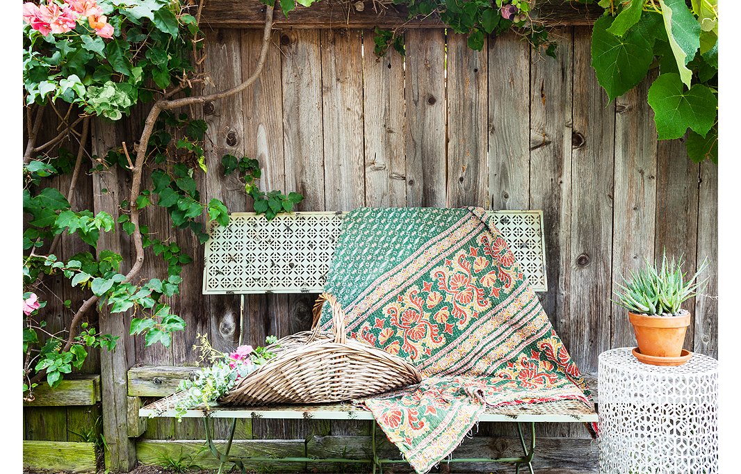 Morris creates a warm and welcoming sitting area by draping a colorful kantha throw over her One Kings Lane bench.
