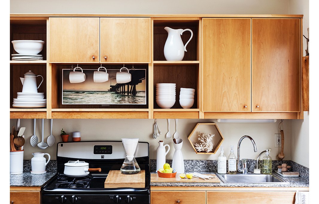 In her open kitchen, Morris opts for functional decor, putting her white dishware on display. Behind the cabinet doors? Drinking glasses fill out the open shelves nicely.
