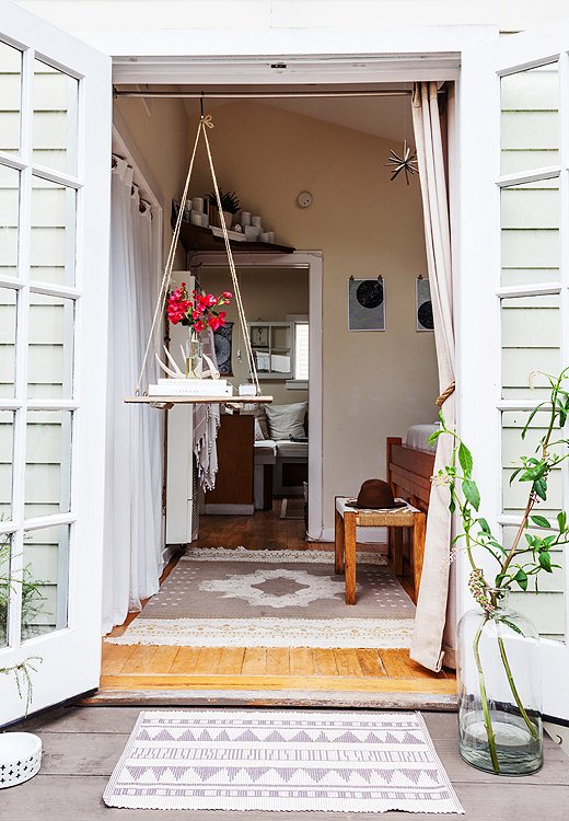 The French doors in Morris’s bedroom open up to a lovely garden space. “We rarely close them,” she says, “but slide a sheer curtain across at night to keep the bugs at bay.”
