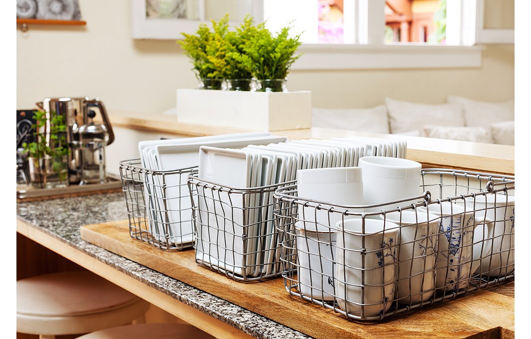 A smart idea for storage and entertaining: Morris keeps plates and mugs organized in metal baskets. No throw-away plates get used by this eco-friendly designer.
