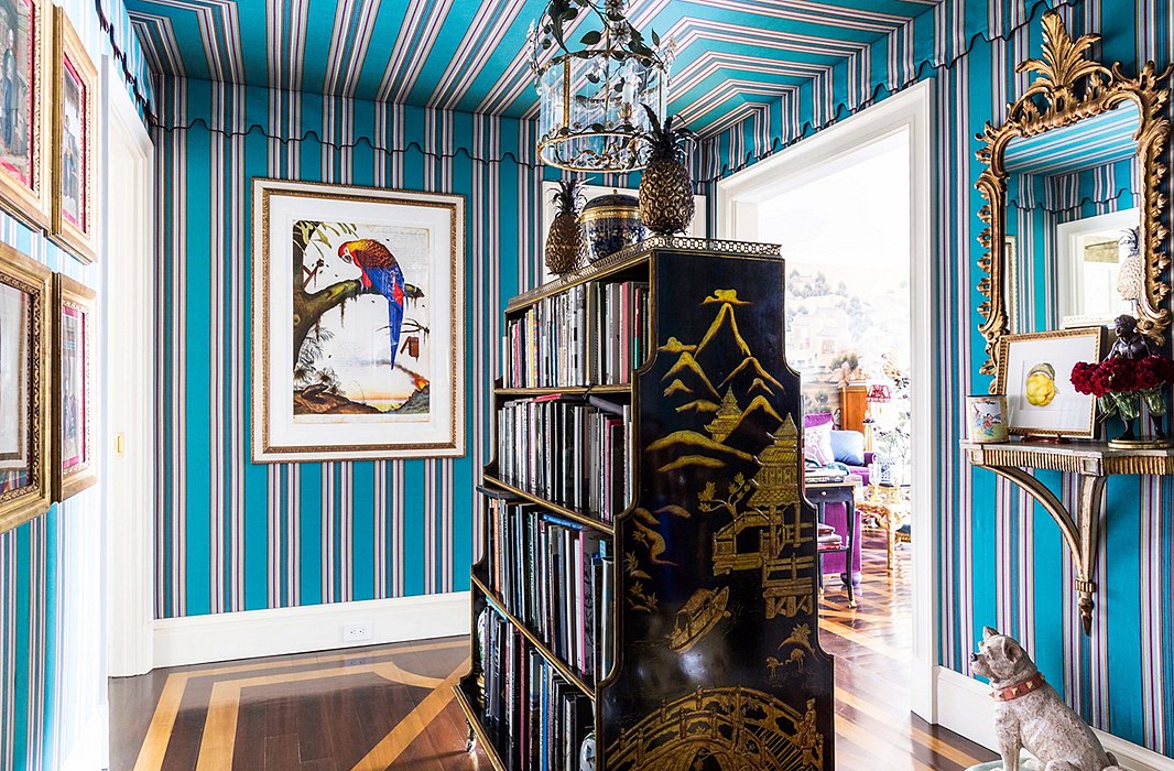 “I thought that the colors were so wonderful and whimsical,” Alex says of the striped Lee Jofa fabric in the entryway. He found the double-sided bookcase while antiquing in Hudson, NY. “There’s nothing I like more than books.”
