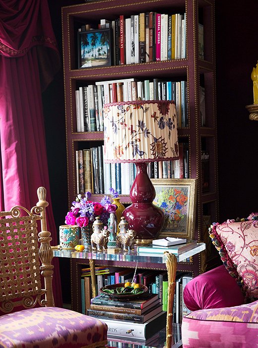 The library bookshelves are packed from floor to ceiling with volumes on art, fashion, and interiors.
