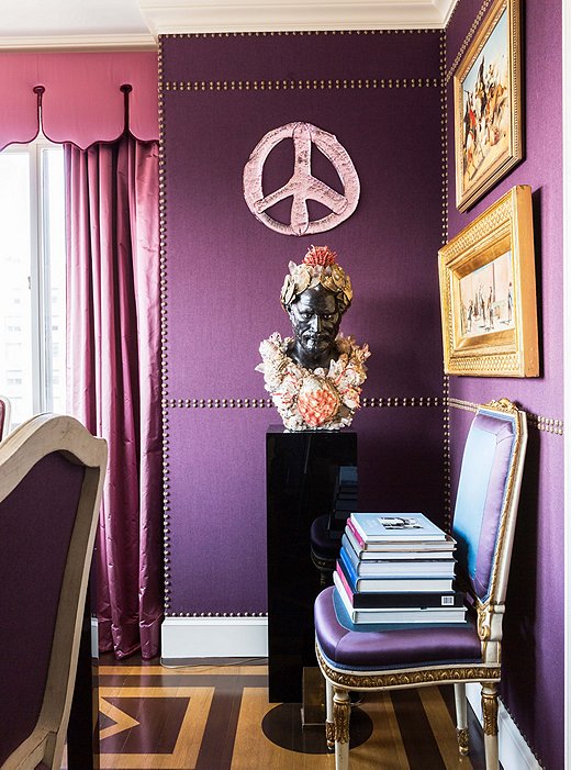 Nail-head trim imitates paneling on the dining room walls. Alex had the shell-covered bust created after an antique spotted in Paris, and the glass peace sign is by favorite artist Rob Wynne.

