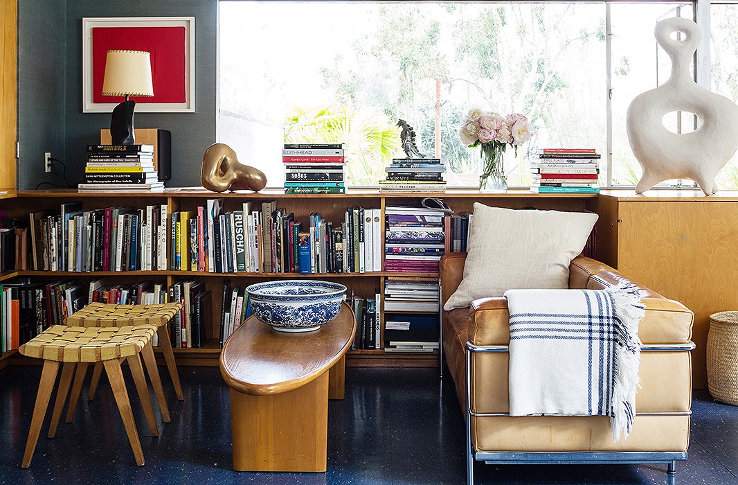 The TV area is where the family “cram onto the leather sofa and watch movies together,” says Liz of their Friday night ritual. The Corbusier seat is paired with a Donald Deskey table, and the stools are by Jens Risom.
