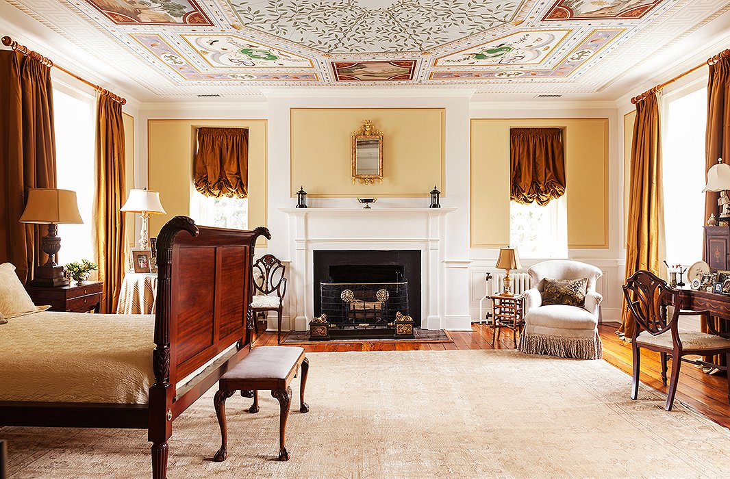 The ceiling of the master bedroom creates the atmosphere of an otherworldly Italian garden. Find fringed armchairs here.
