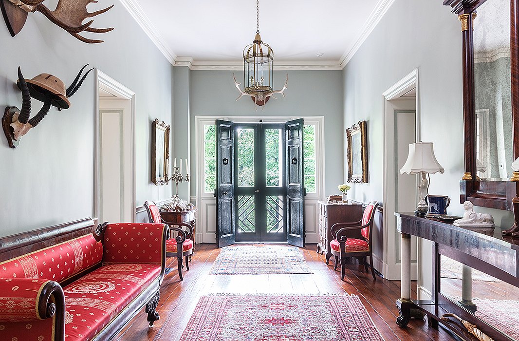 A Federal-style pier table, sofa, and chairs flank the entrance (the seating all upholstered in a Scalamandré red silk). The pieces were designed with looks rather than comfort in mind; as Elizabeth says, “I dare anyone to sit in that sofa and watch a movie!”
