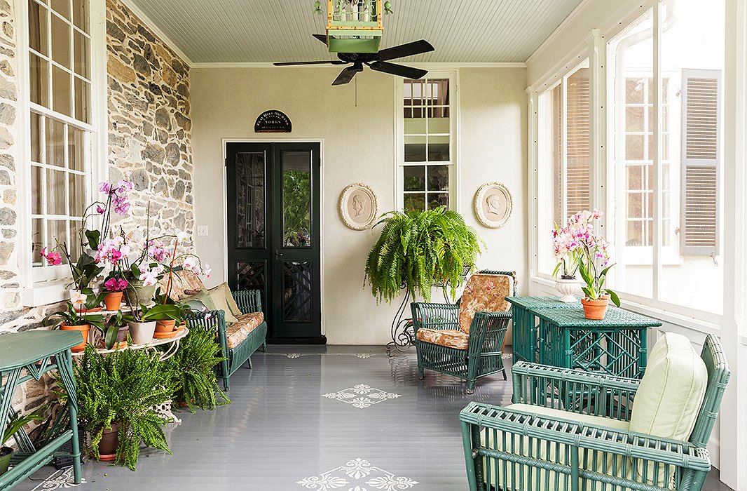 The porch is furnished with antique wicker furniture, collected from various places. Elizabeth painted it all Charleston Green, a deep green with a “giant dollop of black in it.”
