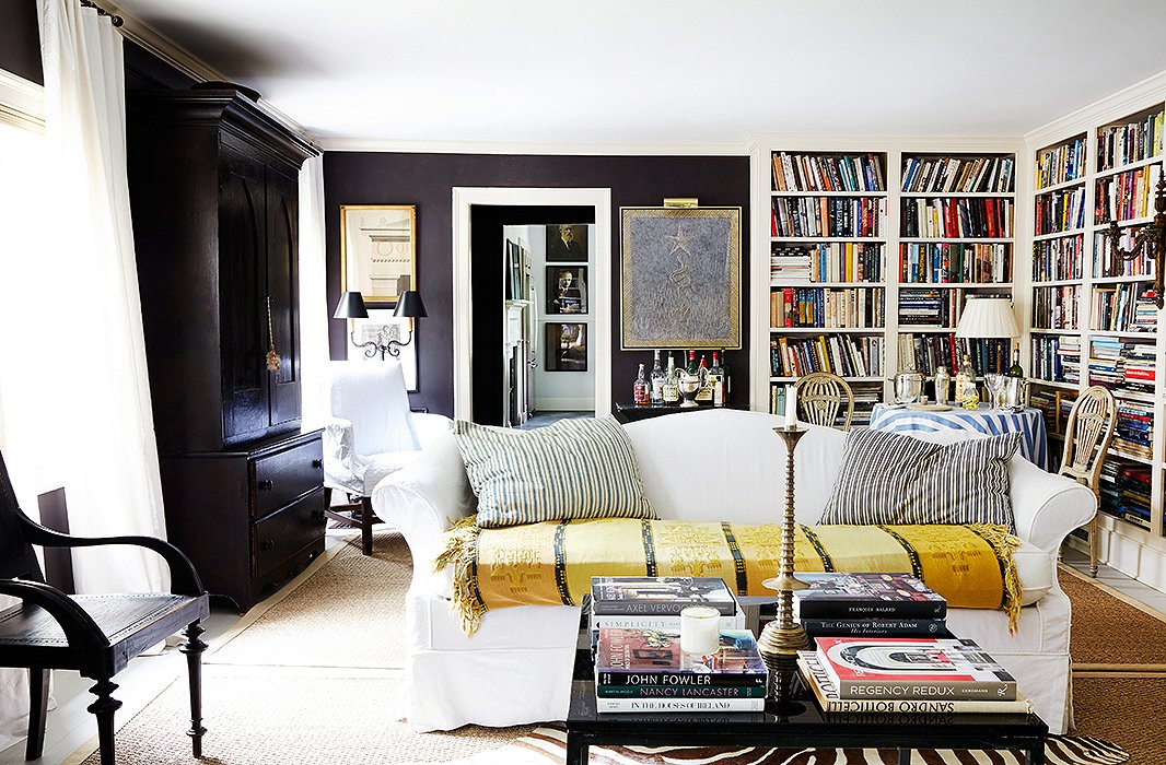 Oversize pillows in two ticking stripe colorways add country charm to a handsome living room. Photo by Pernille Loof.
