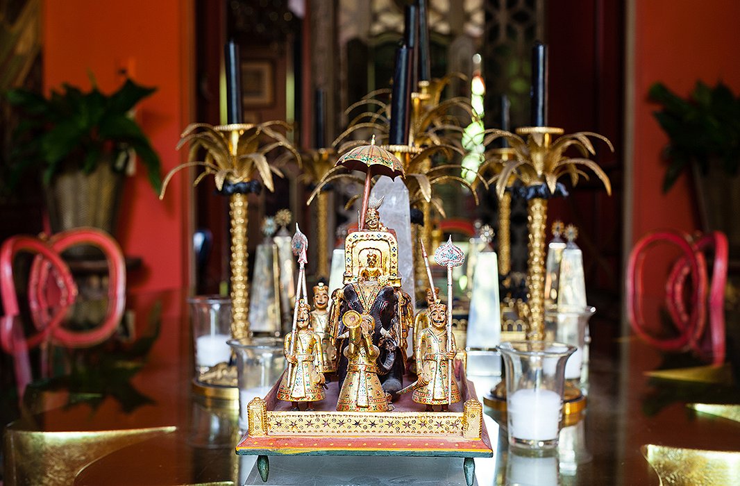 Displayed on the dining table are gilded Indian figures of maharajas riding elephants and golden bronze palm candlesticks by Codognato, the famed Venetian jeweler.
