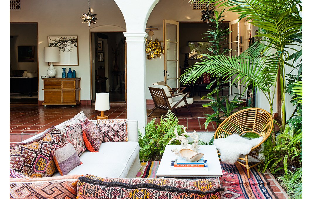 A sleek neutral sofa balances out the riot of color and pattern in the pillows on top—many of which were crafted from vintage rugs. Photo by Nicole LaMotte.
