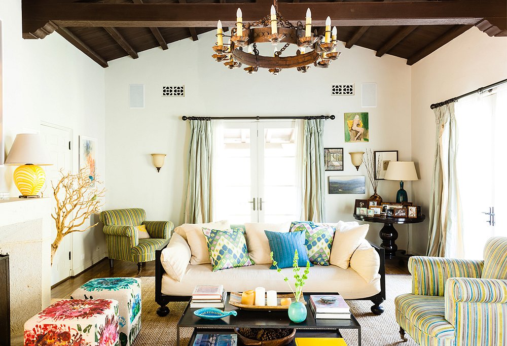 Elegant, contemporary furnishings balance out the living room’s hacienda-style wood ceiling and rustic iron chandelier.
