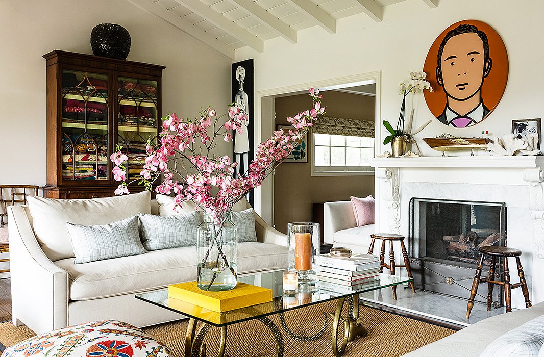 The sitting room is an airer take on New England style. Lulu topped a pair of stylized ram’s heads with glass to make the coffee table, while a piece by British artist Julian Opie hangs over the mantel.

