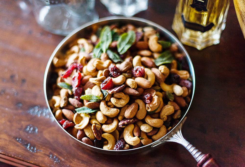 So that everyone doesn’t congregate in only one spot, place bowls of snackables—nuts, olives, chips—in several strategic locations around your home.
