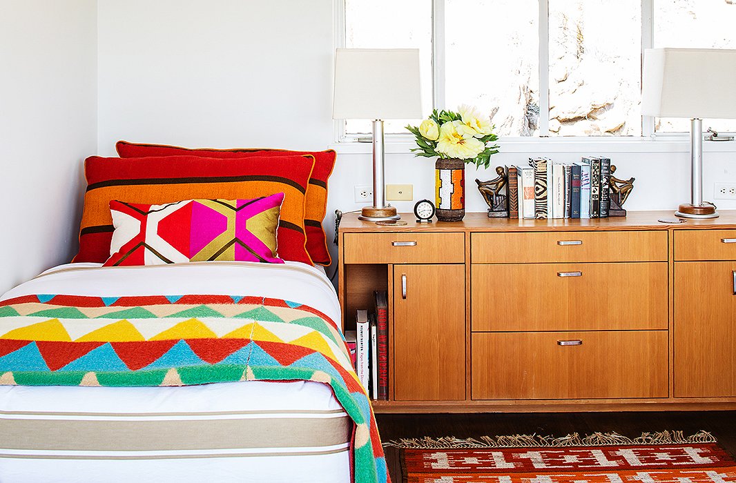 The colorful blanket and pillows bring joie de vivre to what could have been an overly sedate bedroom. Photo by Nicole LaMotte.
