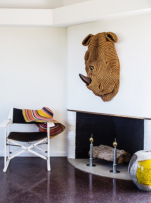 One of the couple’s macramé animal heads takes center stage above the fireplace in the dining area.
