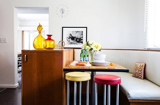 The custom kitchen banquette was lovingly restored postfire after the couple saw the home’s original floor plans. Jonathan bought the Steven Meisel photo at a charity auction. “I loved the original editorial from Italian Vogue,” says Trina.
