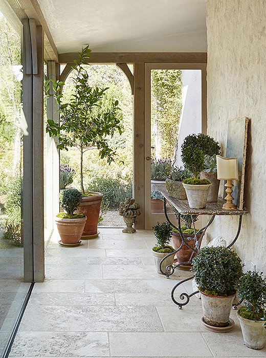 A glassed-in walkway leads to the children’s rooms. “When designing your own home, there is a freedom in experimenting,” says Brooke. “It’s like a laboratory of design ideas.” The pots are from Giannetti Home.
