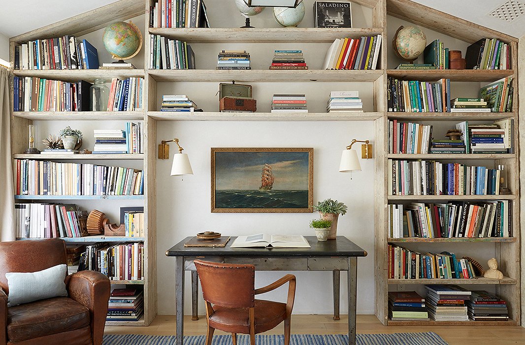 In son Nick’s bedroom, Steve designed a wall of shelving from repurposed scaffolding planks. “He asked for a cool room with storage for his sneaker collection,” says Brooke. “We turned it into a library when he went to college.” The desk is a vintage industrial table.
