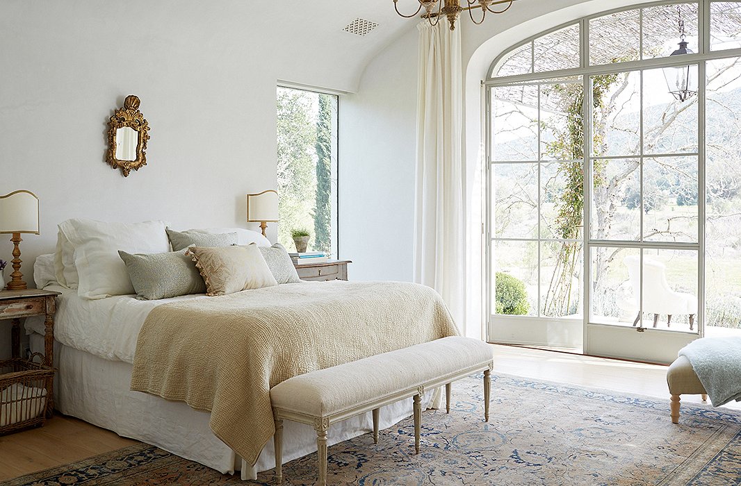 A headboard was initially planned for the couple’s bedroom, but “we realized we wanted it to be ‘less is more,’” Brooke says. Keeping with the minimalist feel, soft Belgian linen and a pixie-size gilded mirror balance the rustic yet refined vibe.
