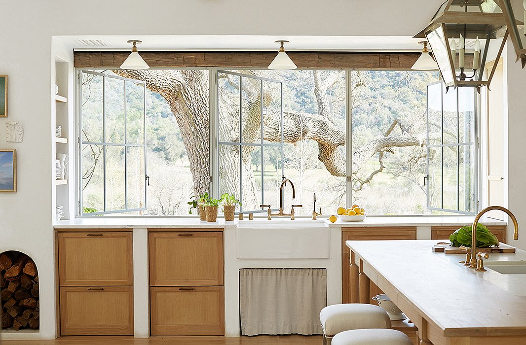 Wanting to harness “every bit of natural light,” Steve designed a wall of windows to connect inside and out and flood the room with sunshine. A farmhouse sink sits atop white-oak cabinets, a material used throughout the home for “a sense of continuity.”
