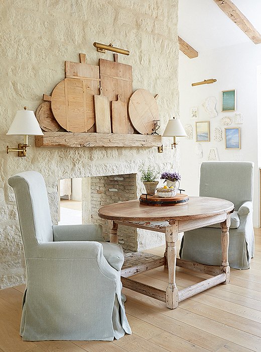 “We eat here every morning,” says Brooke of the kitchen’s dining nook. “The fireplace makes it cozy for winter dinners.” The slipcovered chairs are Giannetti Home, and the couple’s collection of vintage cutting boards gets prime placement. “I felt that they were too pretty to be hidden,” says Brooke.
