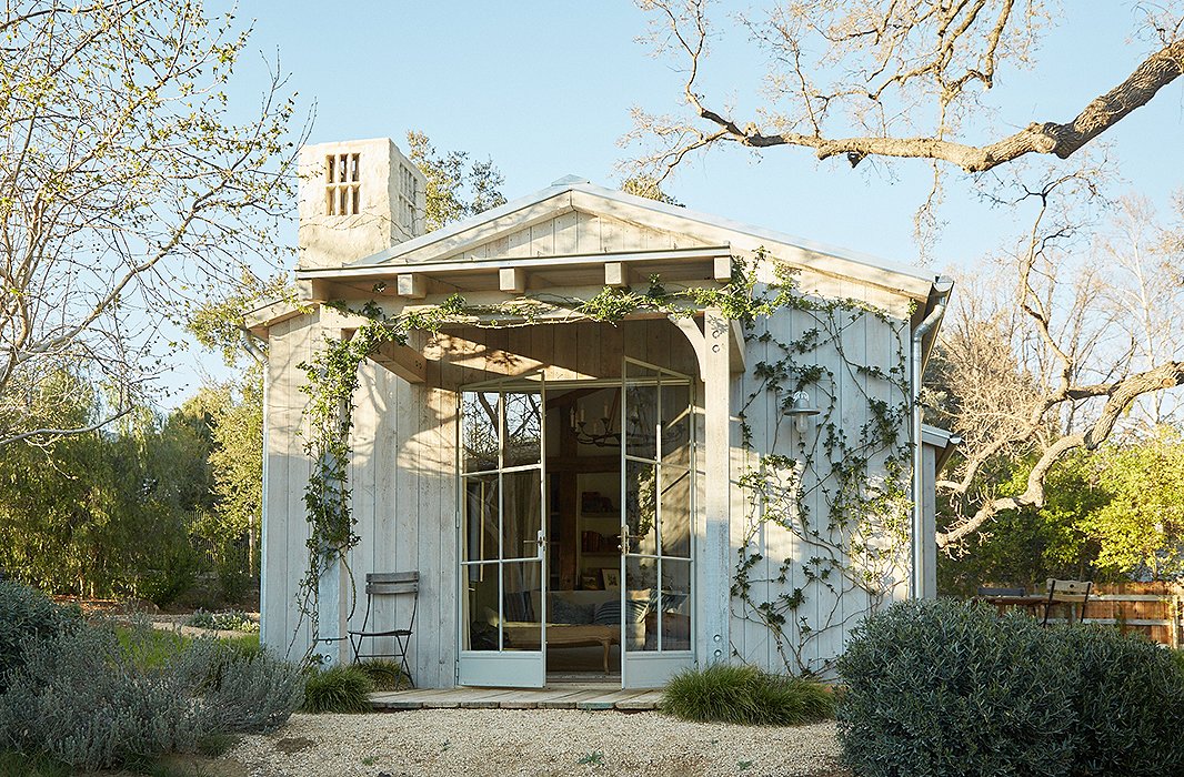 The guesthouse is set next to an old oak tree. “One of our dreams was that this would be a place for our family and friends to visit and share the world we created,” says Brooke. Rose vines frame the entrance for an aromatic welcome.

