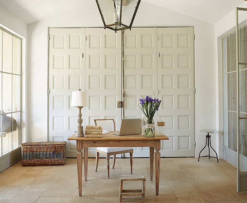 Brooke’s office “feels like a conservatory and surrounds me with the things I love,” she says. “I can see my potager garden and the chickens.” The desk and chair are French and Swedish antiques. Office supplies hide behind the antique doors.
