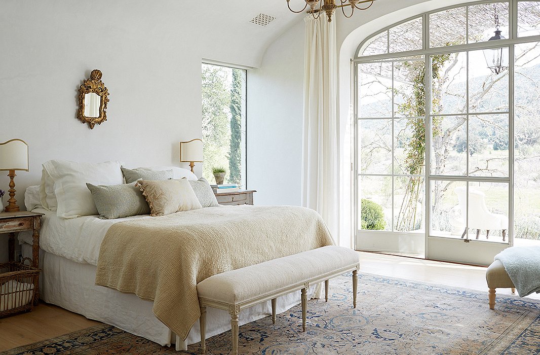 A headboard was initially planned for the couple’s bedroom, but “we realized we wanted it to be ‘less is more,’” Brooke says. Keeping with the minimalist feel, soft Belgian linen and a pixie-size gilded mirror balance the rustic yet refined vibe.