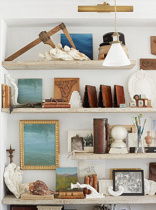 Art leaned on shelves in multiples creates a charmingly laid-back vignette. Photo by David Tsay.
