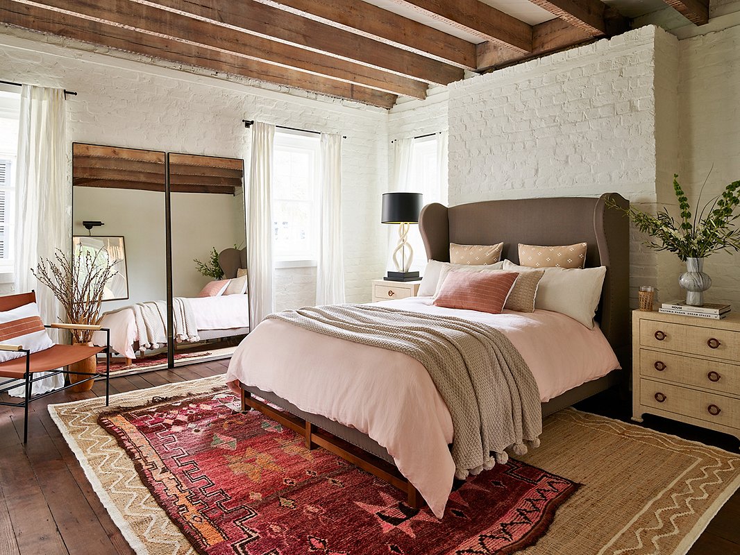 While simple silhouettes dominate Southwestern style, it’s not all straight lines. Case in point: the curves of the Herbert Wingback Bed, the Triple Kudu Horn Table Lamp, and the Stormy Sky Vase. Find the leather-and-iron chair here and the three-drawer raffia-covered nightstand here.
