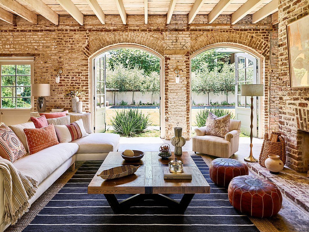 The texture of the oak is the primary decorative element of the Quarter Table (though slender brass inlays along the seams add a touch of sophistication). The linenlike upholstery of the Camila Sectional serves as a foundation for the bevy of richly textured pillows in rusts and browns. Find the leather poufs here and the floor lamp here.
