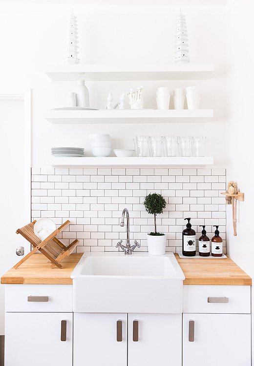 All-white accessories on the kitchen shelves make for a look that’s not just clean but chic as well.

